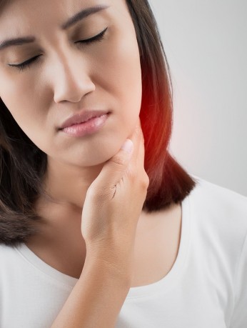 Woman holding her neck near thyroid